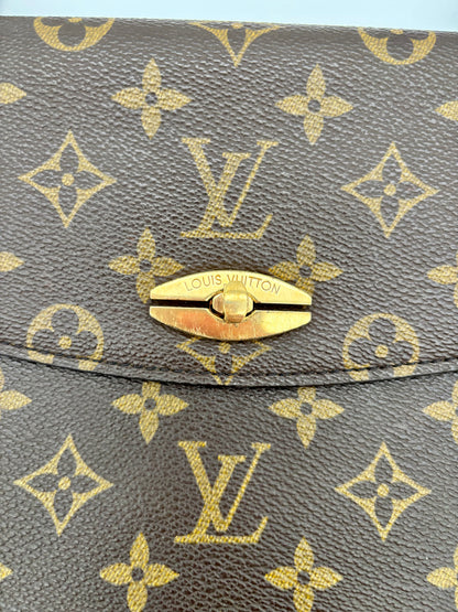 Goldfarbener Drehverschluss auf dem Monogramm-Material der Tasche