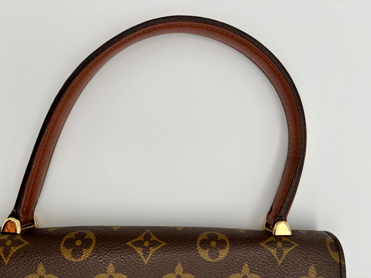 Brauner Henkel mit goldfarbenen Befestigungen an der Tasche