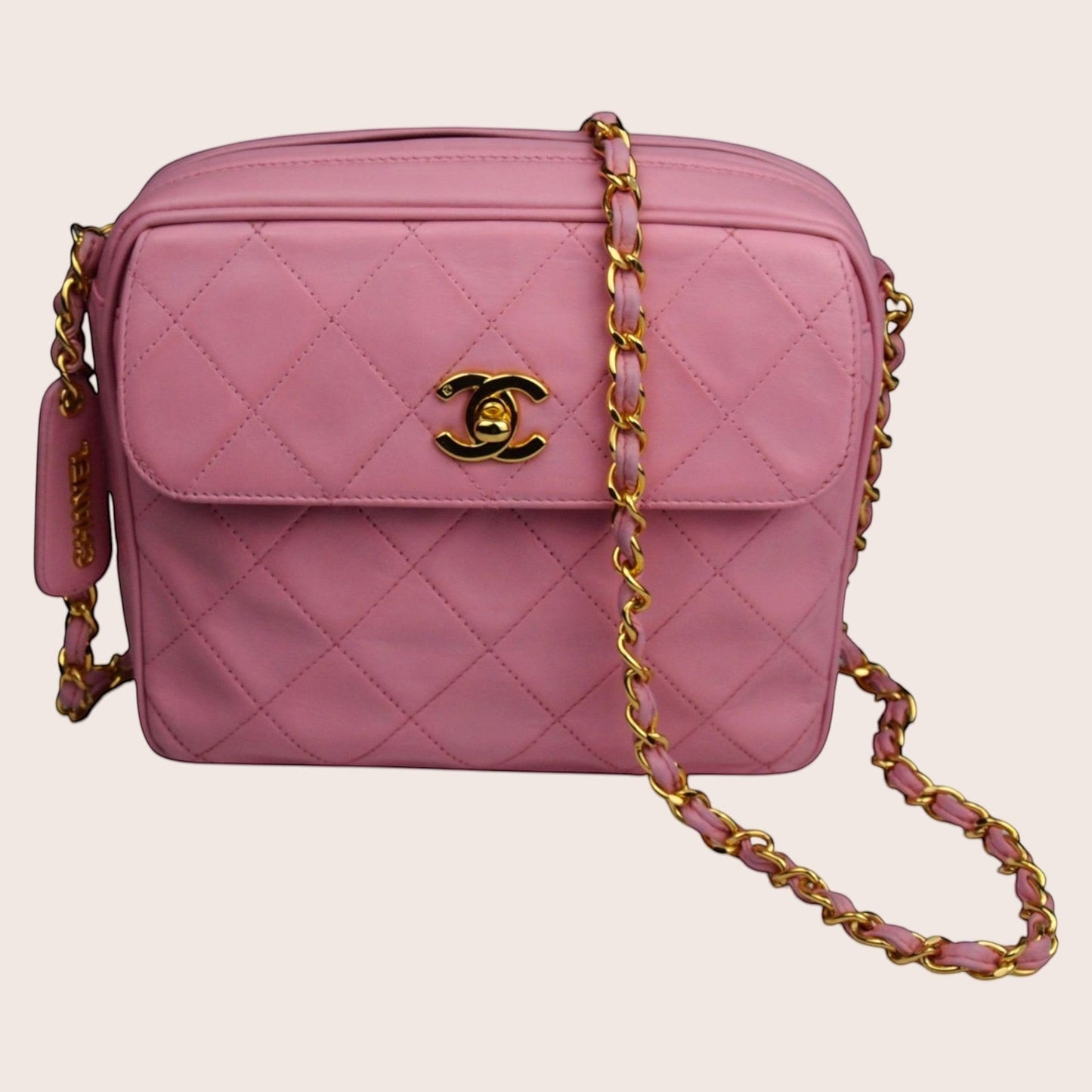 Nandalee pink quilted lambskin Chanel camera bag with gold hardware and tassel detail.
