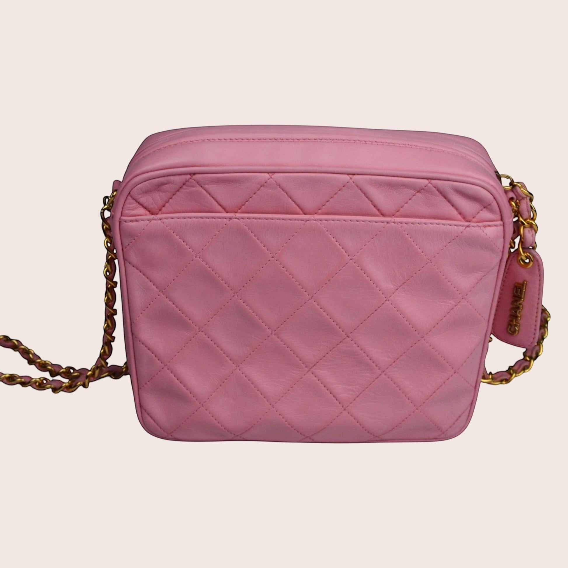 Nandalee pink quilted lambskin Chanel camera bag with gold chain strap and tassel detail.