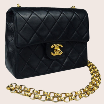 Schräge Seitenansicht der schwarzen Chanel Mini Bijoux Tasche mit goldfarbenen Details.