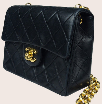 Schräge rechte Seitenansicht der schwarzen Chanel Mini Bijoux Tasche mit goldfarbenen Details.