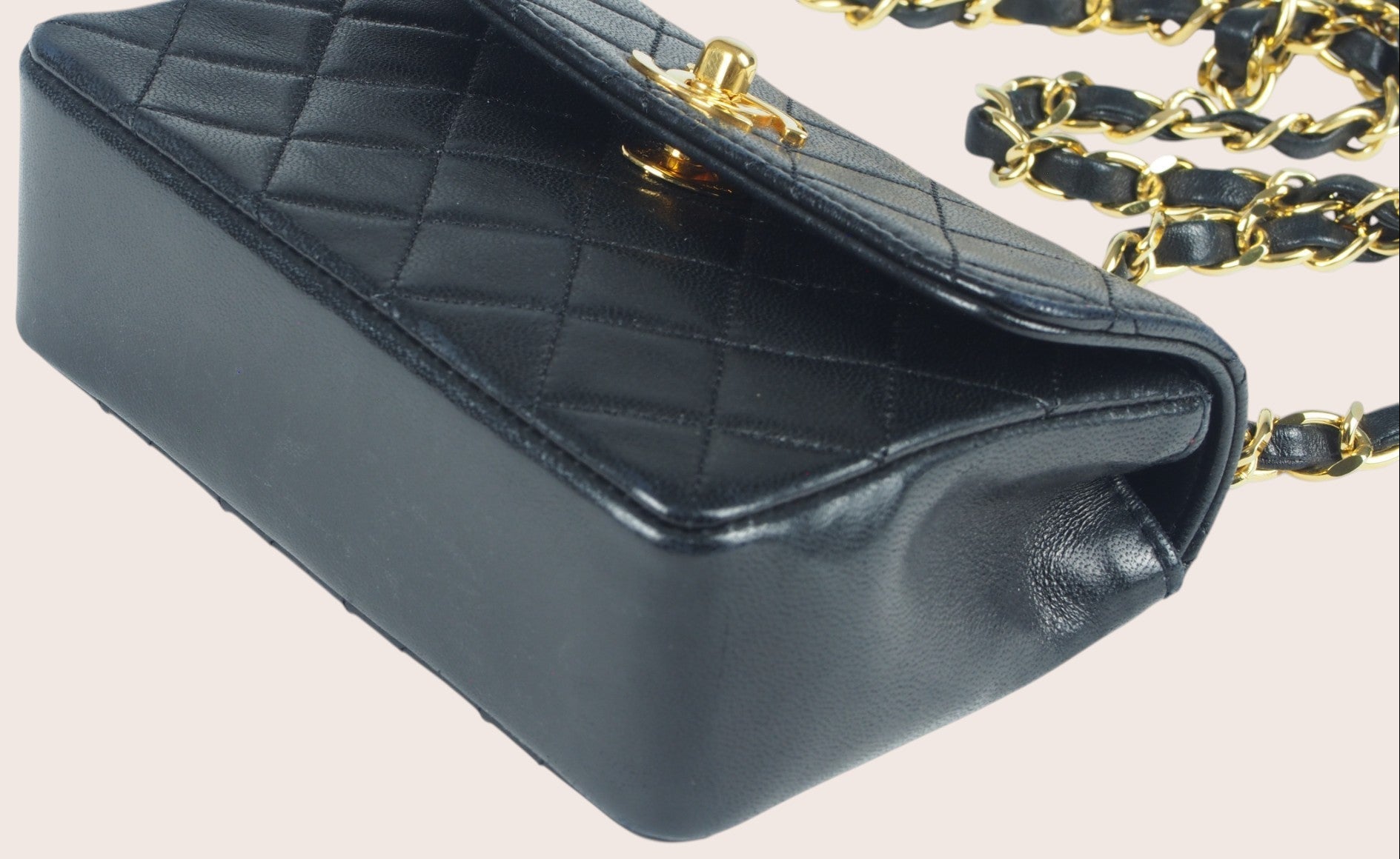 Detailaufnahme der unteren vorderen linken Ecke der schwarzen Chanel Mini Tasche.