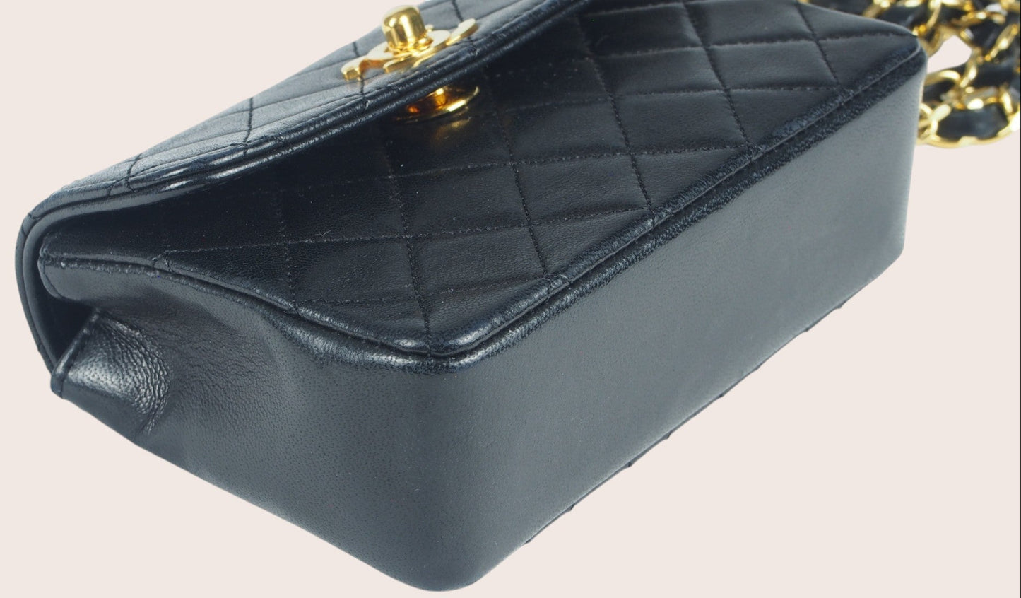 Detailaufnahme der unteren vorderen rechten Ecke der schwarzen Chanel Mini Tasche.