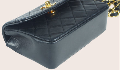 Detailaufnahme der unteren vorderen rechten Ecke der schwarzen Chanel Mini Tasche.