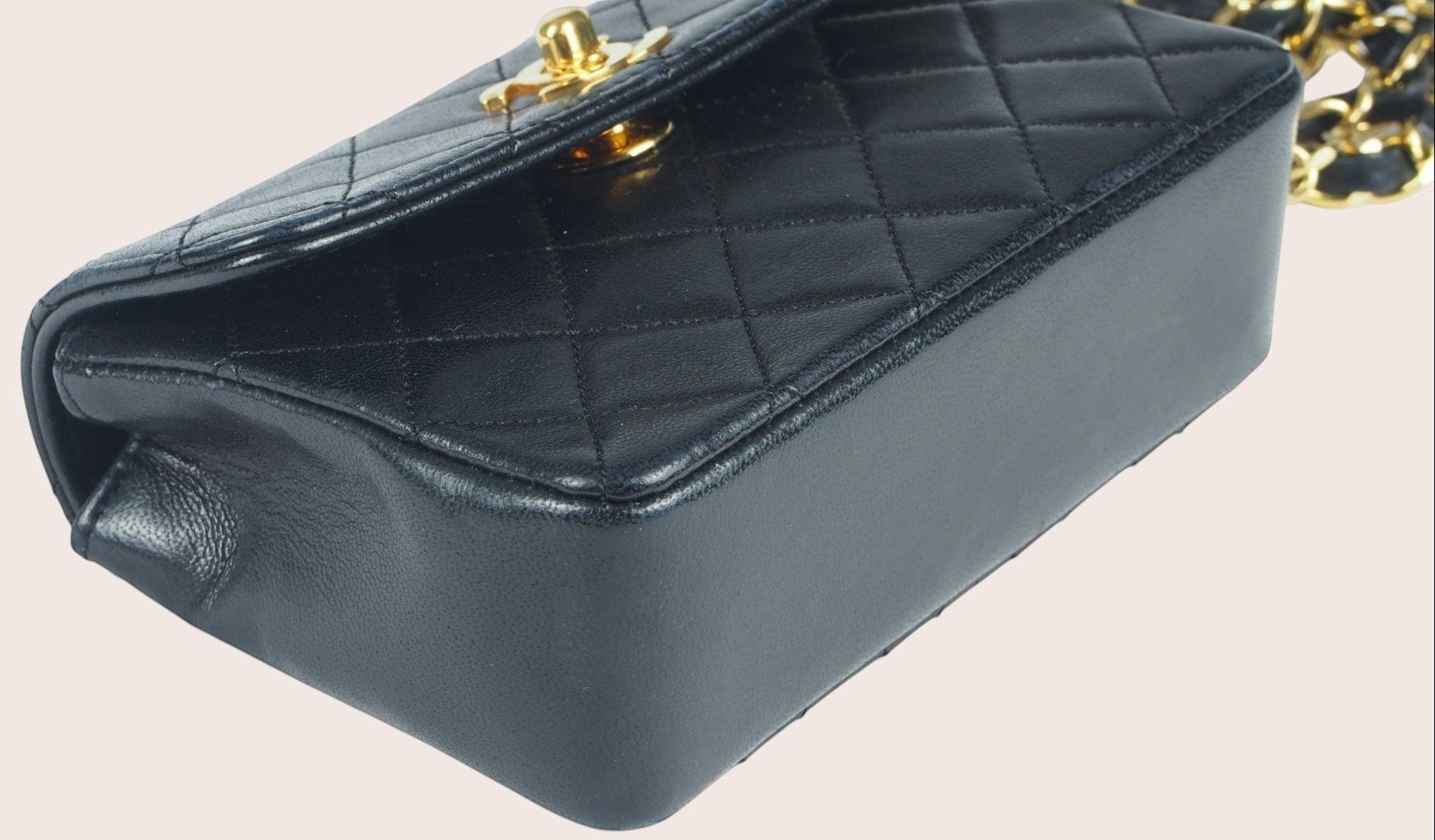 Detailaufnahme der unteren vorderen rechten Ecke der schwarzen Chanel Mini Tasche.