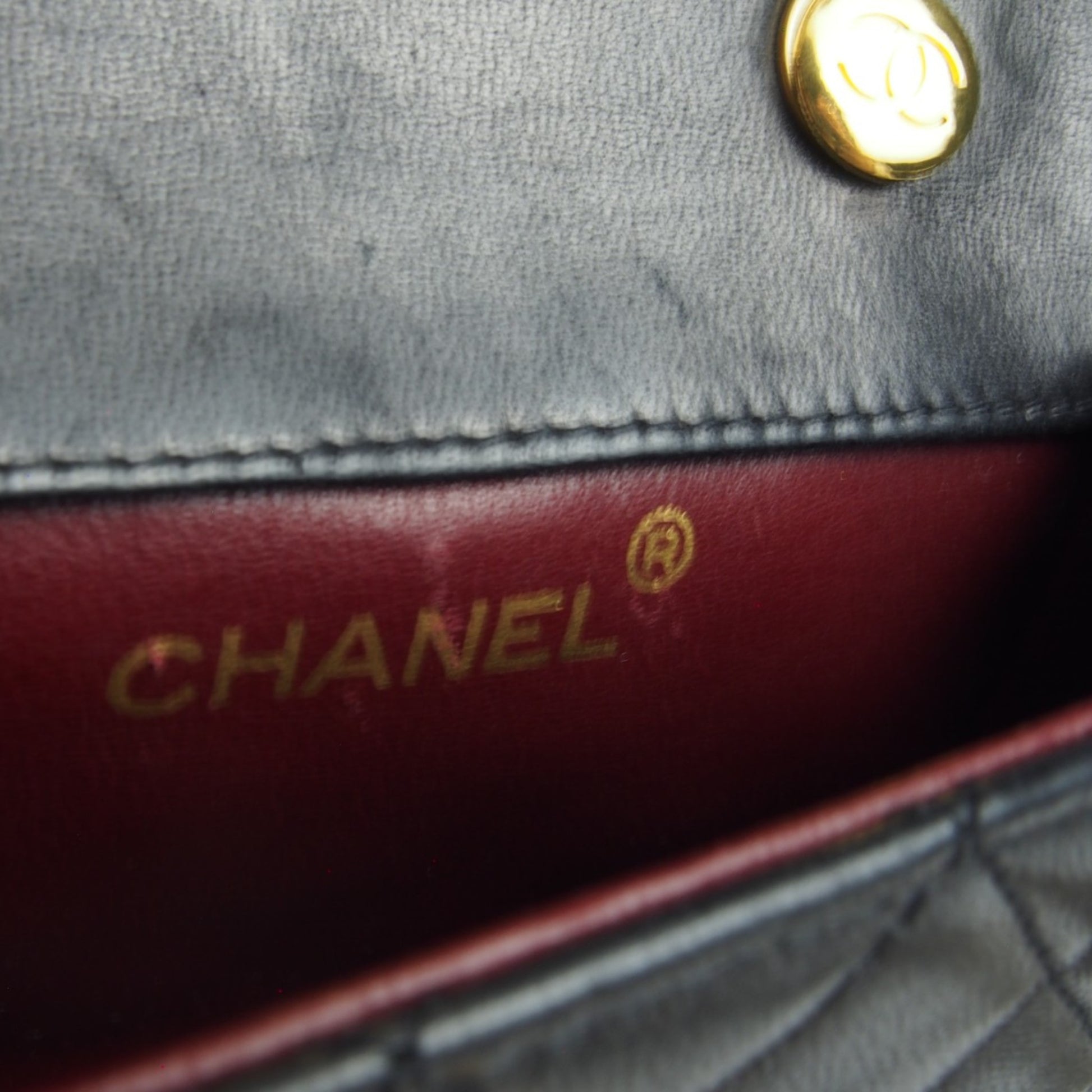 Detailaufnahme des geprägten Chanel Logos im Innenfutter der Chanel Mini Tasche.