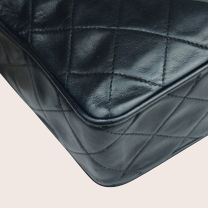 Nandalee black lambskin Chanel Single Flap vintage camera bag with gold chain strap and diamond quilting.