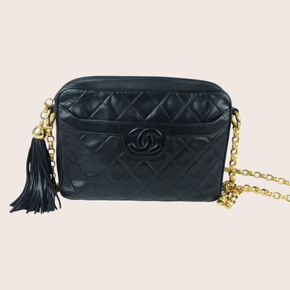 Nandalee black quilted lambskin Chanel Single Flap vintage camera bag with gold chain and tassel.