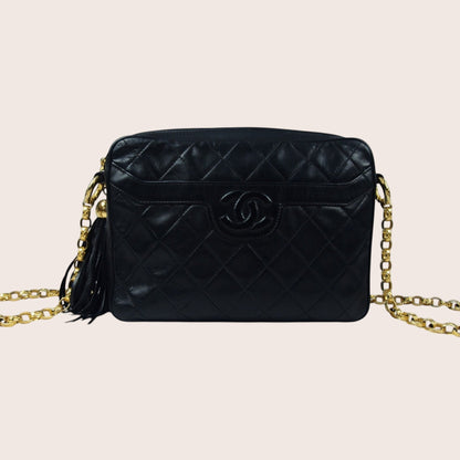 Nandalee black lambskin leather Chanel camera bag with gold chain strap and tassel detail. Vintage single flap design.