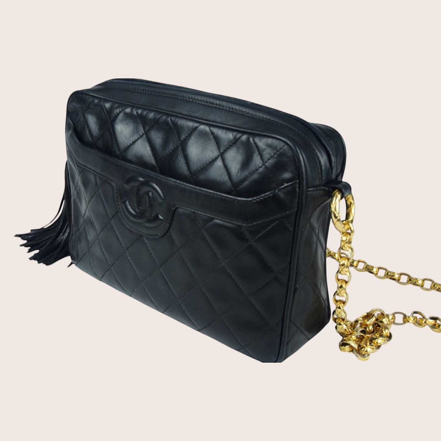 Nandalee black lambskin Chanel Single Flap vintage camera bag with gold chain and tassel detail.