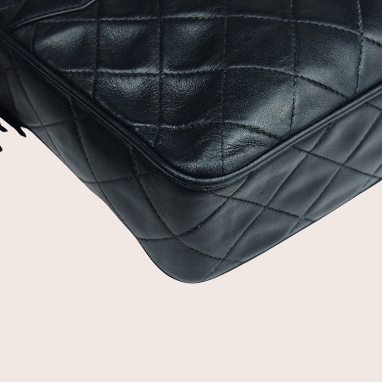 Nandalee black lambskin Chanel Single Flap vintage camera bag with gold hardware and tassel detail.