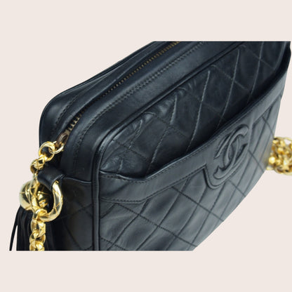 Nandalee black lambskin Chanel Single Flap vintage camera bag with gold chain and tassel.