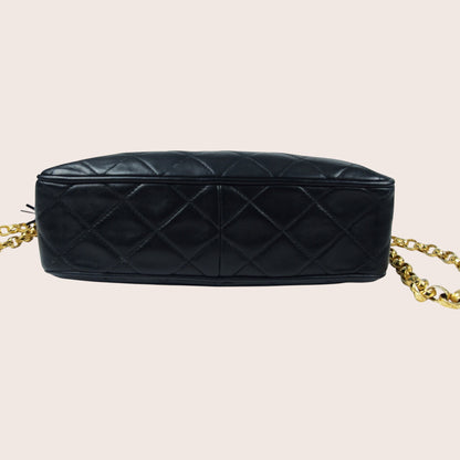 Nandalee black lambskin Chanel Single Flap vintage camera bag with gold chain strap and diamond quilting.