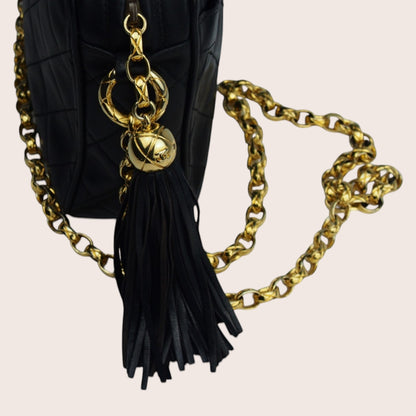 Nandalee black lambskin Chanel Single Flap vintage bag with gold chain and tassel detail.