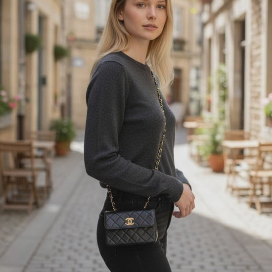 Schwarze Chanel Mini Tasche crossbody getragen mit goldfarbenem Kettenriemen.